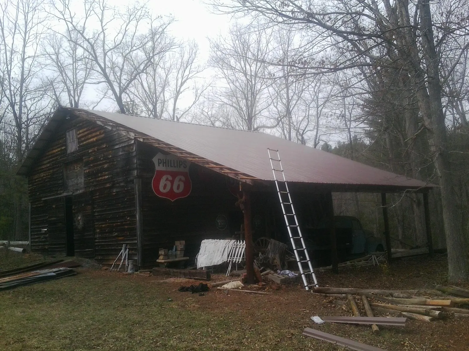 New metal roof on an open sided timber barn with a vintage sign in Logansport