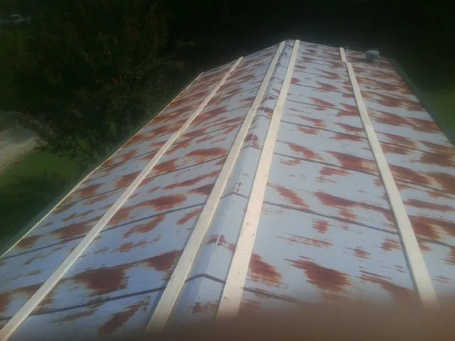 Rusted metal roof panels with new wood purlins before replacement — Storm Damage Roof Repair in Logansport by Roofing Brothers