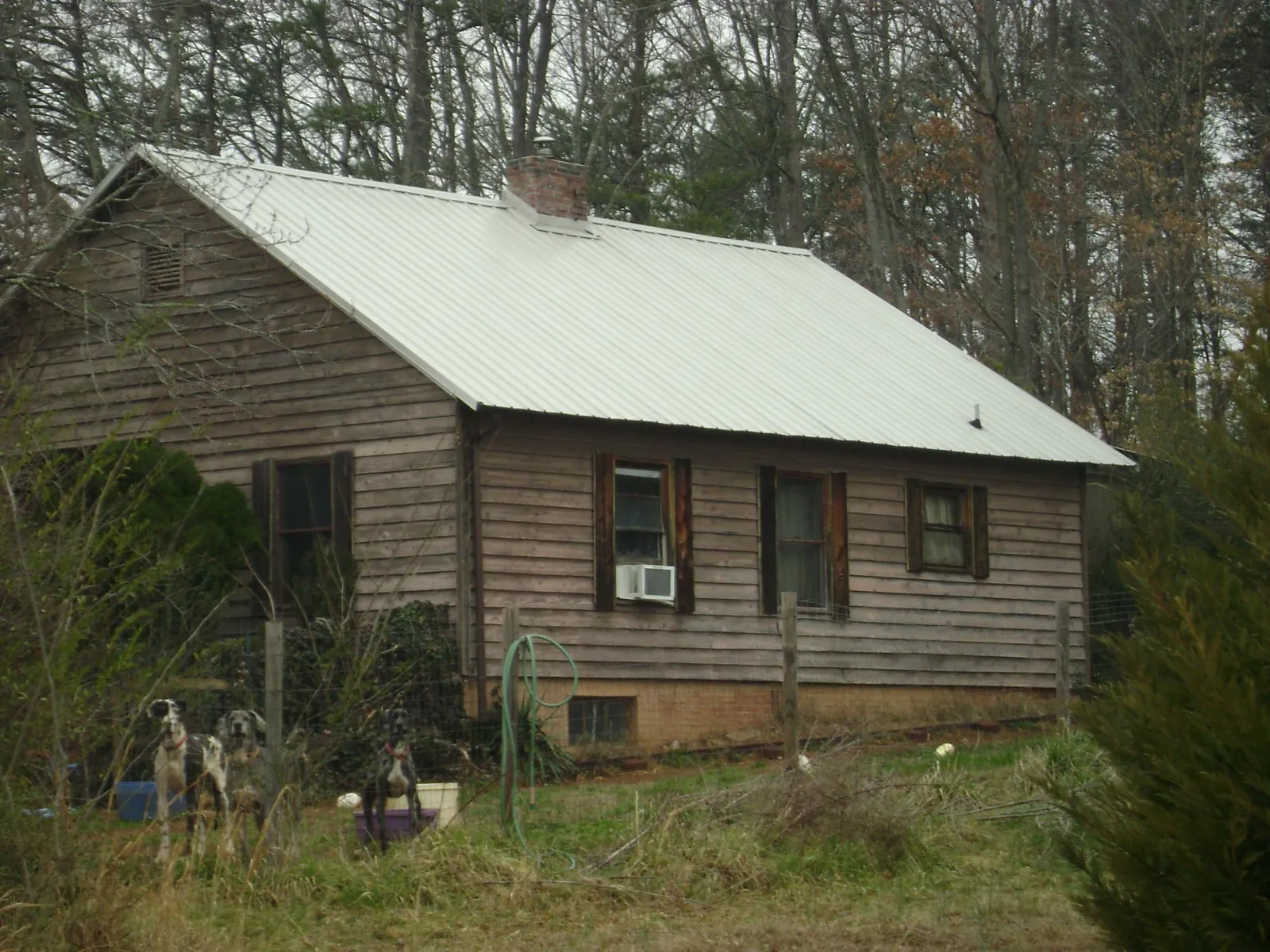 White metal roof on an old wood sided farmhouse, from a Metal Roof Installation job in Logansport